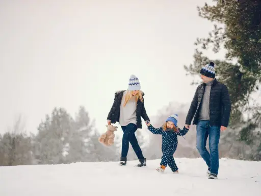 Famiglia felice in vacanze montagna bambini, camminano nella neve con cappelli coordinati.