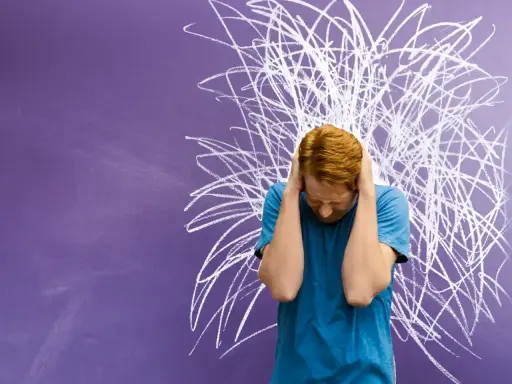 Junge mit roten Haaren hält sich die Ohren zu, vor chaotischer Kreidezeichnung. Ein Bild für die Herausforderungen von Kindern mit ADHS und Distanzlosigkeit.