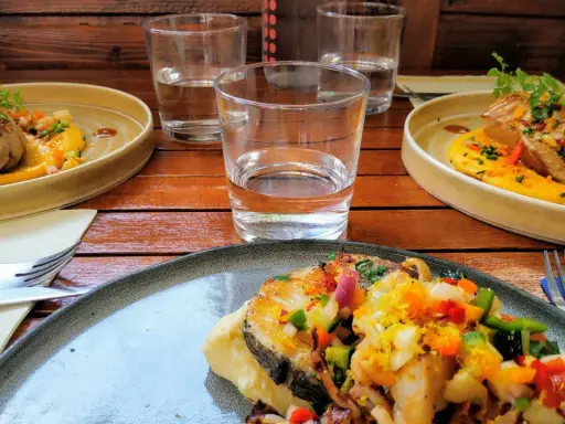 Trois assiettes de poisson grillé, purée de courge, légumes croquants et herbes fraîches. Une spécialité pyrénéenne à déguster.