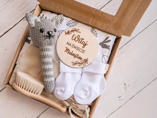 Zestaw na baby shower: szydełkowy kotek, skarpetki, szczotka i tabliczka "Witaj na świecie Maleństwo". Idealny pomysł, ile dać na baby shower.
