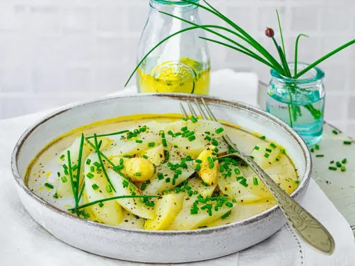 Ein Teller mit Spargel Salat, garniert mit Schnittlauch und einer leichten Sauce.