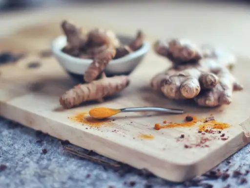 Curcuma fraîche et en poudre sur une cuillère, prête pour le dosage. Idéal pour le bien-être de votre chien.