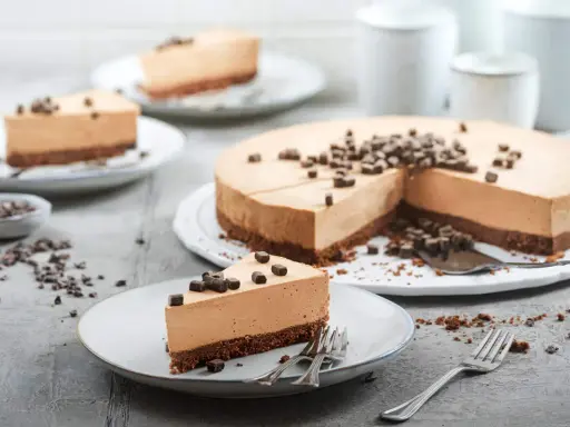 Ein cremiger no bake cheesecake mit Schokoladenstückchen, auf Tellern serviert.