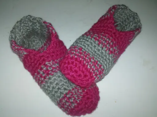 Ett par handvirkade tofflor i rosa och grått. Perfekta för mysiga hemmakvällar.