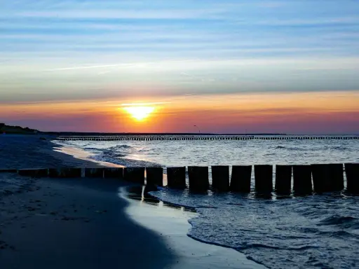 Zachód słońca nad Bałtykiem, falochrony i plaża w Sarbinowie. Piękne atrakcje Sarbinowo.