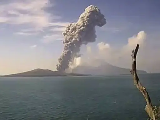 Potężna chmura dymu i popiołu wyrzuca w niebo wulkan Krakatau, tworząc dramatyczny widok nad spokojnym morzem.
