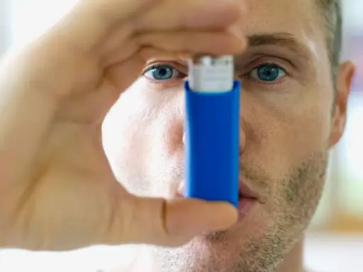 Mann mit Inhalator, bereit gegen **Asthma und Hitze** vorzugehen.