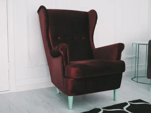 Elegancki, bordowy fotel z aksamitu. Zastanawiasz się, czym wyczyścić fotel z materiału, by wyglądał jak nowy?