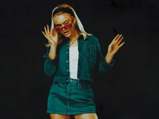 Zara Larsson 2024 i en snygg denim-outfit med röda solglasögon, redo att ta världen med storm.