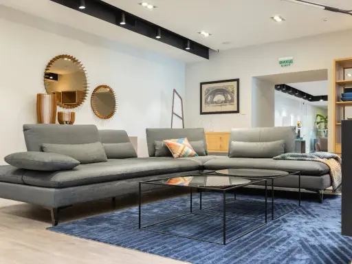 Salones con espejos encima del sofá, creando un ambiente moderno y espacioso.