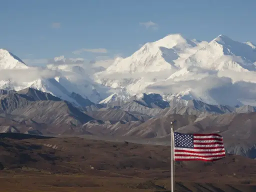 US-Flagge vor schneebedeckten Bergen des Denali Nationalparks.