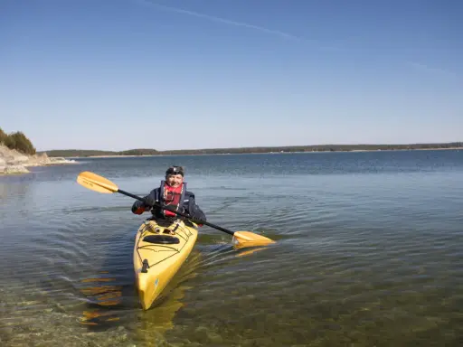 Man paddlar kanot på Gotland i klart vatten.