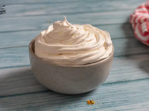 Nata montada perfecta en un cuenco gris, lista para decorar postres.