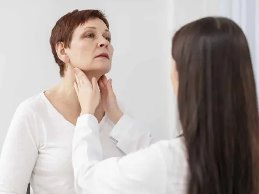 Medico esamina il collo di una paziente, possibile indicazione per una scintigrafia tiroidea.