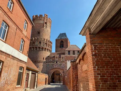 Historische Backsteinarchitektur mit einem runden Turm und Torbogen. Ein tolles Motiv für Ausflugsziele Sachsen-Anhalt.