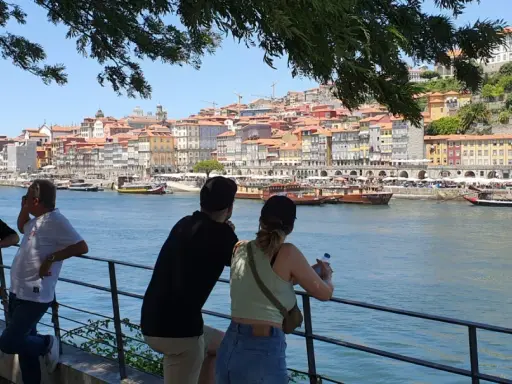 Blick auf Porto mit bunten Häusern und dem Fluss. Eine Gruppe genießt die Aussicht, eine tolle Porto Card Erfahrung.