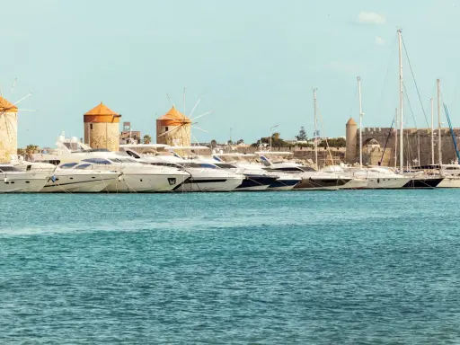 Väderkvarnar och lyxyachter i hamnen vid Rhodos stad. En historisk karta över Rhodos stad skulle visa denna vy.