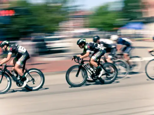Ciclistas en carrera, capturados con un barrido fotográfico que resalta la velocidad y el movimiento.