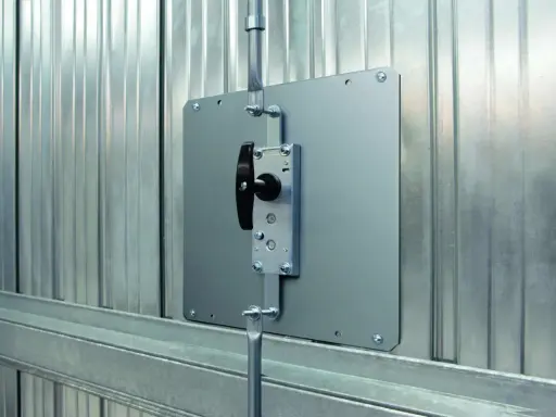 Système de verrouillage pour securiser porte garage. Poignée noire sur plaque métallique fixée sur porte en métal ondulé.