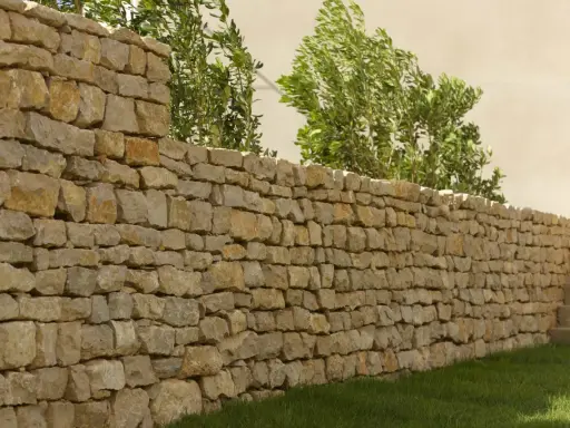 Un muret en pierre sèche, bordé d'herbe verte et de verdure luxuriante, s'étend sur la droite, menant à des marches en pierre.