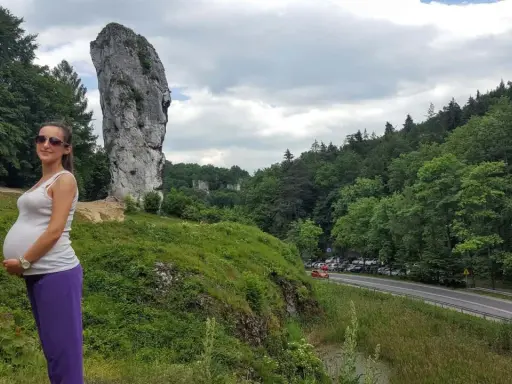 Kobieta w ciąży cieszy się pięknym krajobrazem, idealnym miejscem, gdzie na wakacje w ciąży.
