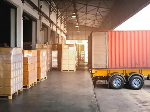 Almacén con camión y contenedores listos para la normativa de carga y descarga de camiones.