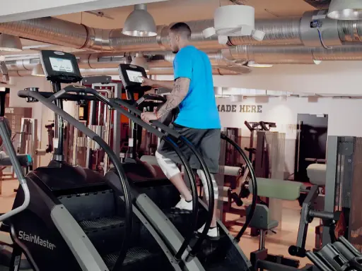Mann trainiert auf einem Stairmaster im Fitnessstudio.