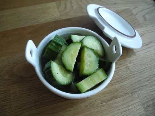 Snabbsaltad gurka i en vit skål, redo att serveras. Enkel och god tillbehör.