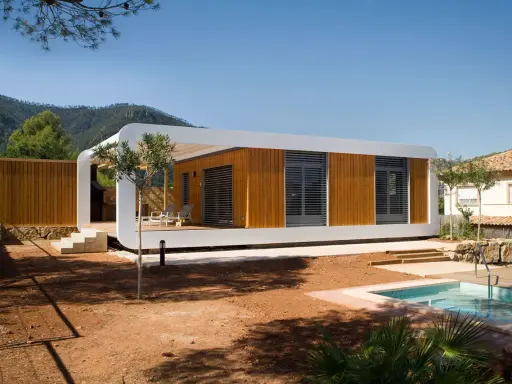 Une maison écologique moderne en bois avec une piscine et une vue sur les montagnes.
