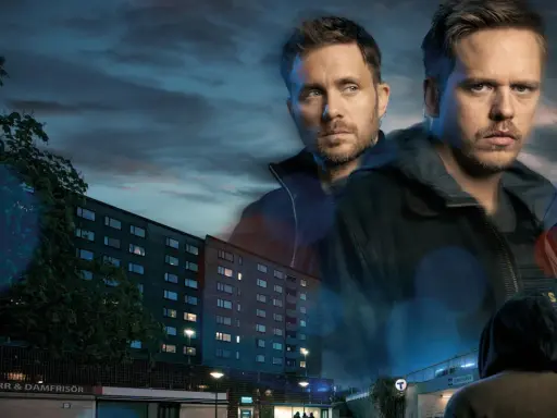 Två män i förgrunden, en lägenhetsbyggnad och en tunnelbanenedgång i bakgrunden. En scen från en tv4 film.