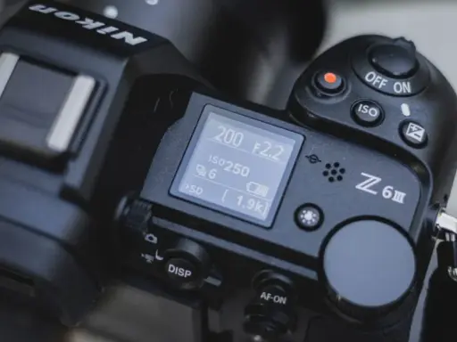 Górna część aparatu Nikon Z6 III z widocznym ekranem LCD, pokrętłem trybów i przyciskiem nagrywania.