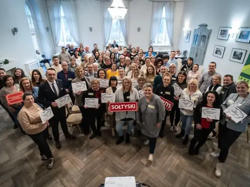 Grupa osób trzyma tabliczki z napisami, m.in. "SOŁTYSKI", "Podnosimy wyzwania", "Ale ENERGIA!".