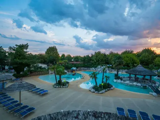 Villaggio vacanze con piscine azzurre, palme e lettini prendisole. Un angolo di paradiso, un vero tahiti camping village.