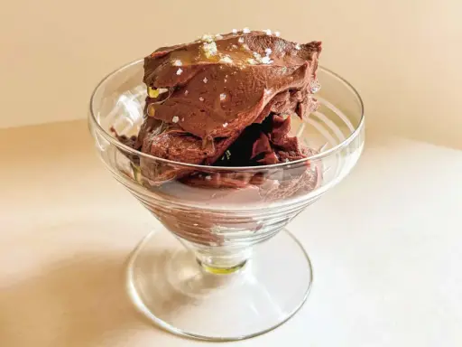 Glace au chocolat intense, parsemée de sel de mer et d'un filet d'huile dorée. Une délicieuse ganache coco pour un plaisir gourmand.
