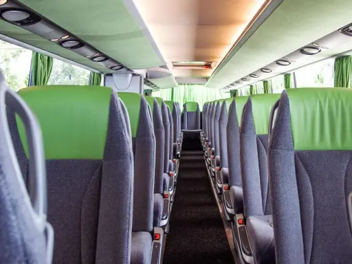 Leere Sitze im Bus, bereit für die Fahrt von Setúbal nach Lissabon. Grüne und graue Polster, Blick in den Gang.