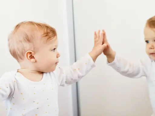 Bambino che tocca il suo riflesso, un momento chiave nella costruzione del sé nel bambino.