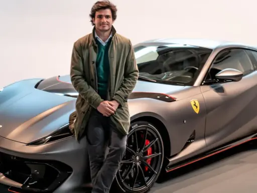 Carlos Sainz posa junto a un Ferrari gris mate, listo para la próxima carrera.