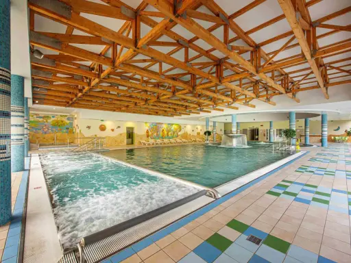 Wnętrze basenu z jacuzzi i kaskadą. Sprawdź bardejowskie termy cennik i zaplanuj relaks.