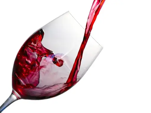 Czerwone wino leje się do kieliszka, tworząc wiry. Ile promili w lampce?