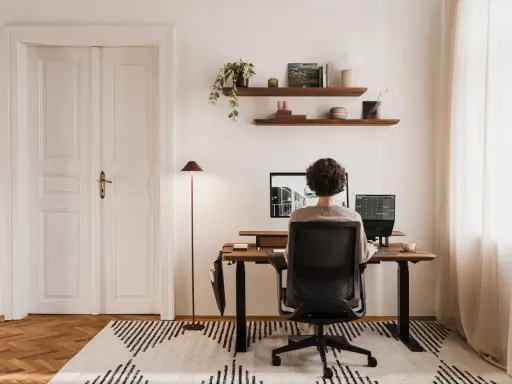 Un espace de travail épuré, avec une personne assise à son bureau, créant le bureau idéal.