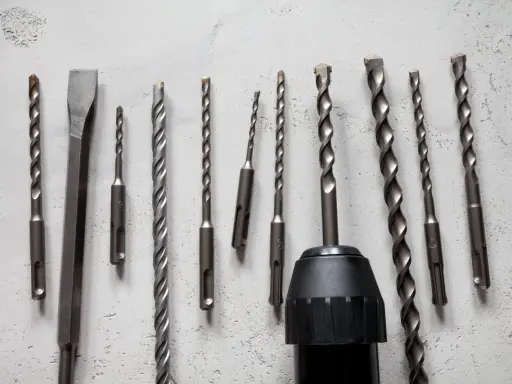 Variedad de tipos de mandriles para taladros, incluyendo brocas para concreto y un cincel, listos para cualquier trabajo.