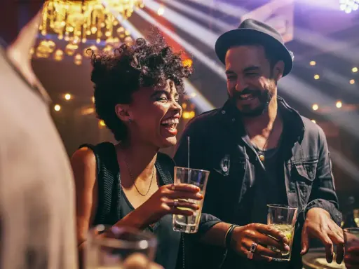 Coppia felice ride e beve in un locale notturno di Barcellona, tra luci soffuse e musica.