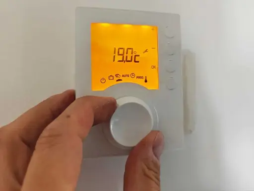 Réglage de la température de la salle de bain à 19°C avec un thermostat.