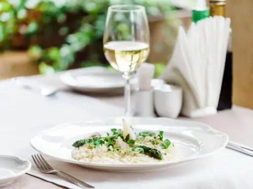 En krämig risotto med sparris och örter, perfekt ackompanjerad av ett glas vitt vin till risotto.