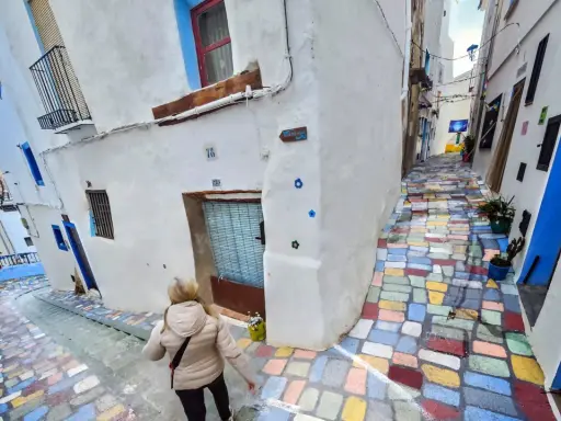 Callejuela de **Chelva pueblo azul**, con escalones de colores vibrantes y casas blancas adornadas con detalles azules.