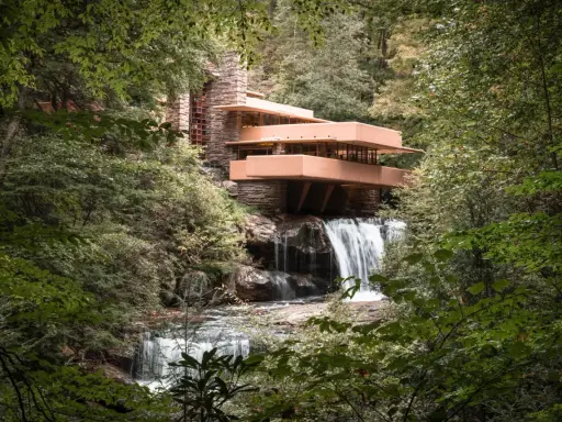 Casa de la Cascada, una obra maestra de las estructuras diseñadas por Frank Lloyd Wright, se alza sobre una cascada en un bosque frondoso.