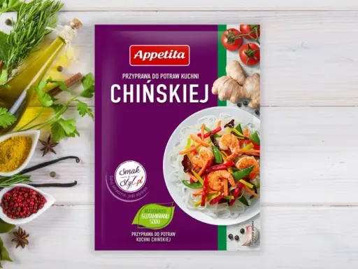 Opakowanie przyprawy do dań kuchni chińskiej Appetita. Obok świeże zioła, czosnek, imbir, pomidorki i składniki, jakie przyprawy do chińszczyzny.