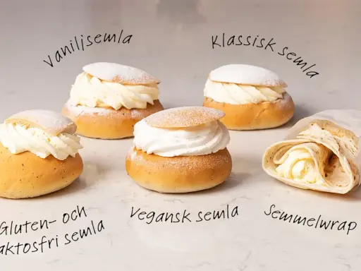 Fem olika semlor och en semmelwrap på ett marmorbord. Perfekt för semlor dagen!