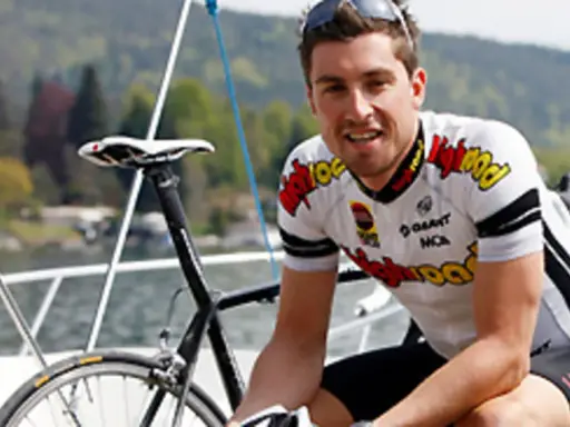 Bernie Eisel, Radsportler, lächelt neben seinem Rennrad auf einem Boot.
