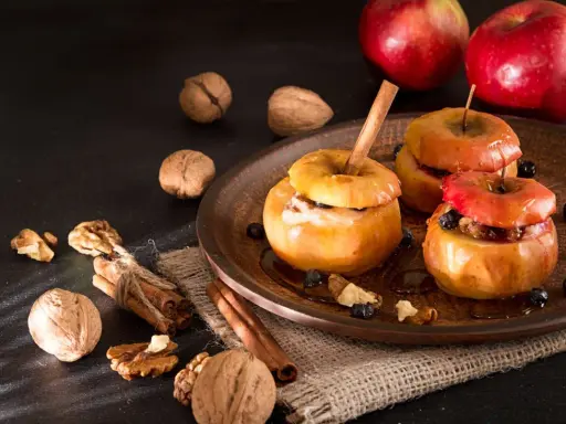 Deliciosas manzanas asadas con canela, nueces y arándanos, listas para disfrutar.